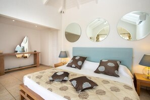 Ein Schlafzimmer mit einem Bett, zwei Nachttischen, einem Spiegel und einem Wandregal.