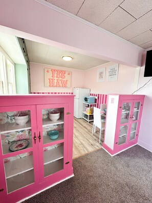 Interior - Rhinestone Cowgirl is a chic pink-inspired upper-level apartment just blocks from downtown Russell. Enjoy a cozy bedroom, living area with Smart TV, kitchenette, full bath, private balcony, and shared backyard with grill, firepit, and laundry. (Russell)