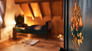 A cozy room with a bed, a lamp, and a wooden ceiling. - Holiday Home Lilace with Hot Tub, Fireplace, 4 Bedrooms, Max. 8 Guests (Böttingen)