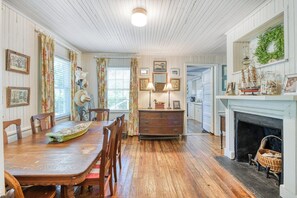 A dining room with wooden furniture, a fireplace, and a kitchen visible through an open door. - 4 Bedroom 2 Bath Inlet Front Home with Deep Water Access (Murrells Inlet)