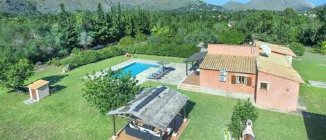 Finca mallorquina con piscina privada, amplio jardín y vistas a la sierra en un entorno natural.