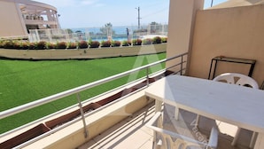 A balcony with a view of a swimming pool and a green lawn. - GRAND T2 AVEC TERRASSE, GARAGE ET PISCINE (Sète)