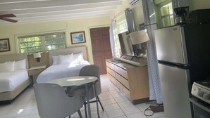 Ein Hotelzimmer mit Bett, Schreibtisch, Stuhl, Kühlschrank und Klimaanlage.