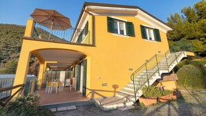 A yellow building with a balcony, outdoor seating, and a staircase. - ‘Acacia’ Apartment with Sea View, Wi-Fi and Air Conditioning (Ceriale)