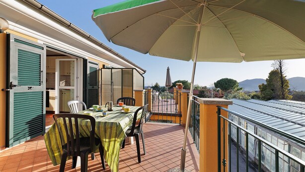 A balcony with a table, chairs, and an umbrella. - 'Carrubo' Apartment with Sea View, Wi-Fi and Air Conditioning (Ceriale)