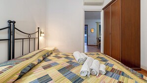 A bedroom with a bed, a wooden wardrobe, and a hallway leading to another room. - Apartment 'Ginestra' with Mountain View, Wi-Fi and Air Conditioning (Ceriale)