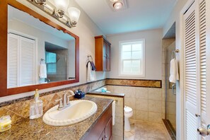 A bathroom with a sink, mirror, cabinet, toilet, and shower. - Quiet 3BR Retreat, EV Charger, Fenced Yard (Tide) (Westport)