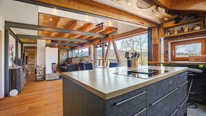 A spacious kitchen with a large island, wooden beams, and a view of the outdoors. - Apartment 'I'd Love To Be Home' with Shared Pool, Shared Terrace and Wi-Fi (Bidingen)