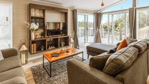Een moderne woonkamer met een televisie, bank en salontafel.