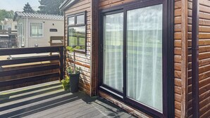 Una cabana de fusta amb finestres grans i un balcó.