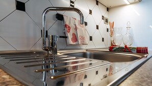 A modern kitchen with a stainless steel sink, a towel rack, and a glass decanter set on the counter. - Charming apartment with private parking near the Cremona Racing Circuit (Casteldidone)