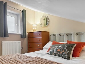 A bedroom with a bed, a dresser, a mirror, and a radiator. - 1 bedroom accommodation in Skipton (Skipton)