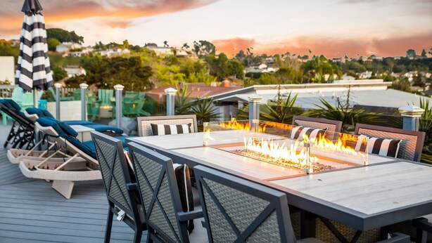 Una terraza con mobiliario exterior, una chimenea y vistas del entorno.