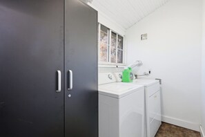 A laundry area with a washing machine and dryer, a window, and a door.