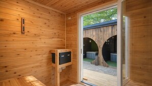 A wooden sauna room with a sliding glass door leading outside. - Cute Cabin, 2 Queens W Shared Hot Tub + Sauna (Easley)