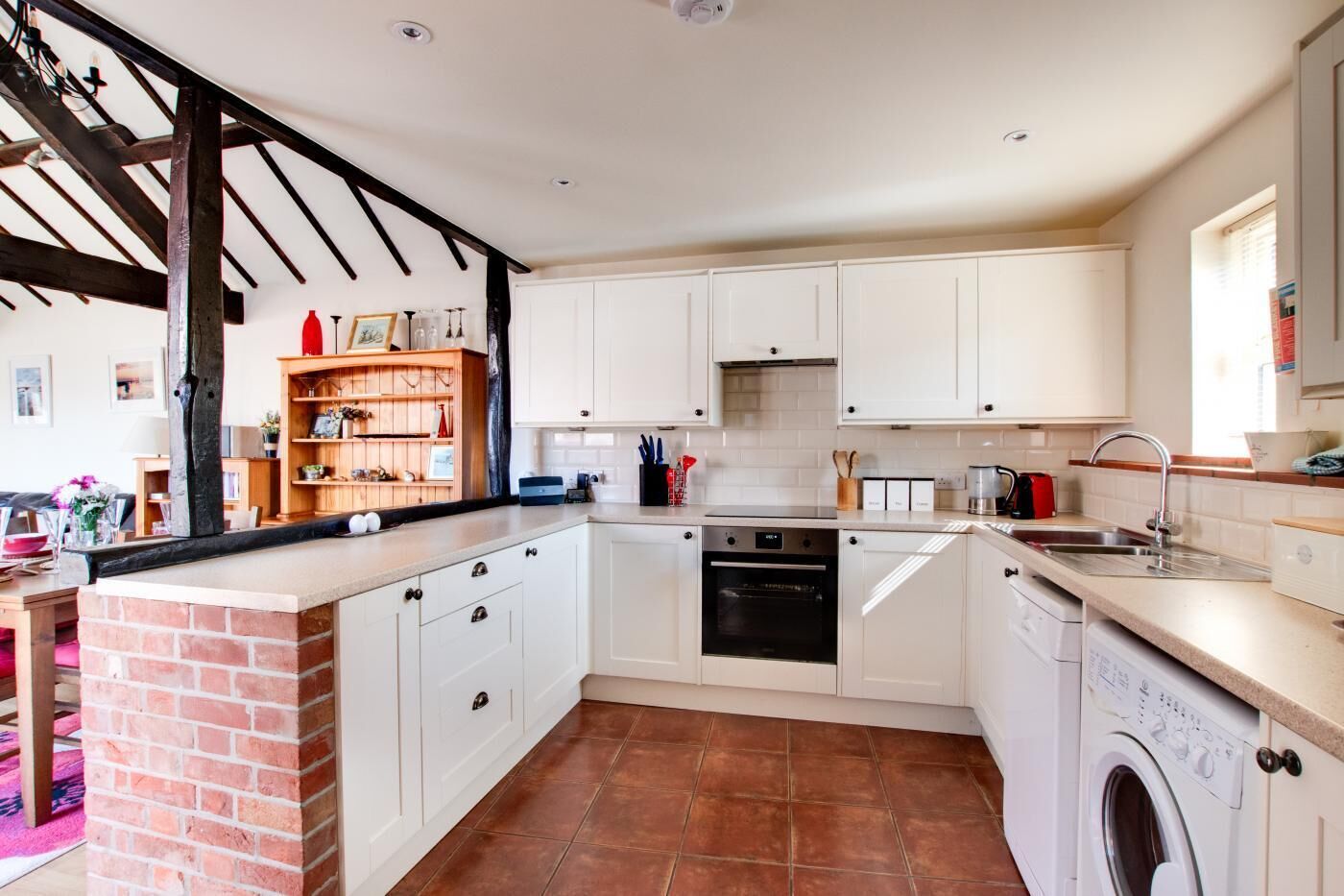 Een microgolfoven, een oven, een vaatwasser, kookgerei, borden en bestek