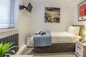 A bedroom with a bed, bedside table, lamp, and a framed picture on the wall. - 3 Bed in Cardiff (oc-bow65) (Cardiff)