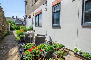A narrow alley with a white building, outdoor seating, and potted plants. - 3 Bed in Cardiff (oc-bow65) (Cardiff)
