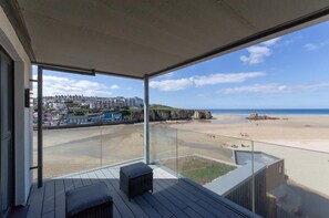 A balcony with a view of a beach and a town.