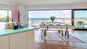 Eine moderne Küche mit Meerblick, ein Essbereich, der für eine Mahlzeit gedeckt ist, und ein großes Fenster.