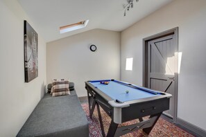 A pool table in a room with a clock on the wall, a door, and a small window. - 3 Bed in North Creake (oc-1916) (North Creake)
