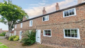 A traditional brick house with multiple windows and a door, surrounded by a gravel driveway and greenery. - 3 Bed in Crayke (oc-y056) (Crayke)