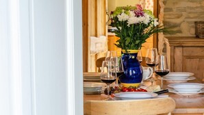 A dining table set with plates, glasses, and a blue vase with flowers. - 3 Bed in Crayke (oc-y056) (Crayke)
