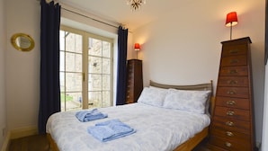 A bedroom with a bed, two bedside lamps, a dresser, and a window with curtains. - 1 Bed in Alnwick (oc-nb312) (Embleton)