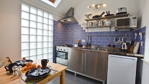 A modern kitchen with a skylight, stainless steel appliances, and blue-tiled walls. - 1 Bed in Alnwick (oc-nb312) (Embleton)