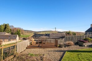A rural property with a fenced backyard, a wooden deck, and a stone building. - 2 Bed in Chatton (oc-nb620) (Chatton)
