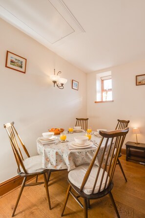 A dining area with a round table, four chairs, and a window. - 2 Bed in Chatton (oc-nb620) (Chatton)