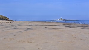 A wide sandy beach with a lighthouse in the distance. - 2 Bed in Morpeth (oc-nb596) (Low Hauxley)