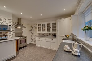 A modern kitchen with white cabinetry, a built-in oven, a microwave, and a gas stove. - 2 Bed in Warkworth (oc-nb319) (Warkworth)