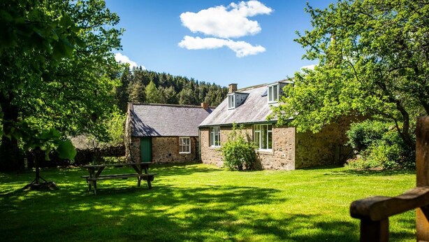 A stone cottage with a grassy yard and a picnic table. - 2 Bed in Wooler (oc-nb317) (Kirknewton)