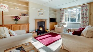 A cozy living room with a fireplace, comfortable seating, and a bookshelf. - 2 Bed in Wooler (oc-nb317) (Kirknewton)
