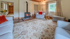 A cozy living room with a fireplace, wooden beams, and patterned carpet. - 2 Bed in Wooler (oc-nb396) (Kirknewton)