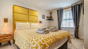 A hotel room with a bed, bedside tables, a window with curtains, and a radiator. - 2 Bed in Padstow (oc-p00714) (Padstow)