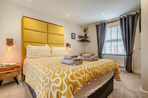 A hotel room with a bed, bedside tables, a window with curtains, and a radiator. - 2 Bed in Padstow (oc-p00714) (Padstow)