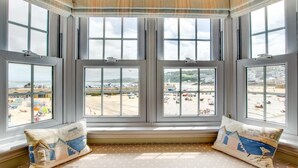 A bay window with multiple panes overlooking a beach. - 1 Bed in St Ives (oc-lhse) (St Ives)