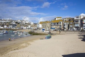 A coastal town with buildings along the shore, a sandy beach, and several boats in the water. - 1 Bed in St Ives (oc-lhse) (St Ives)