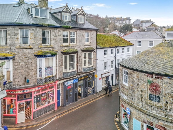 A street view with stone buildings, shops, and a round building with a sign. - 1 Bed in St Ives (oc-decke) (Saint Ives)
