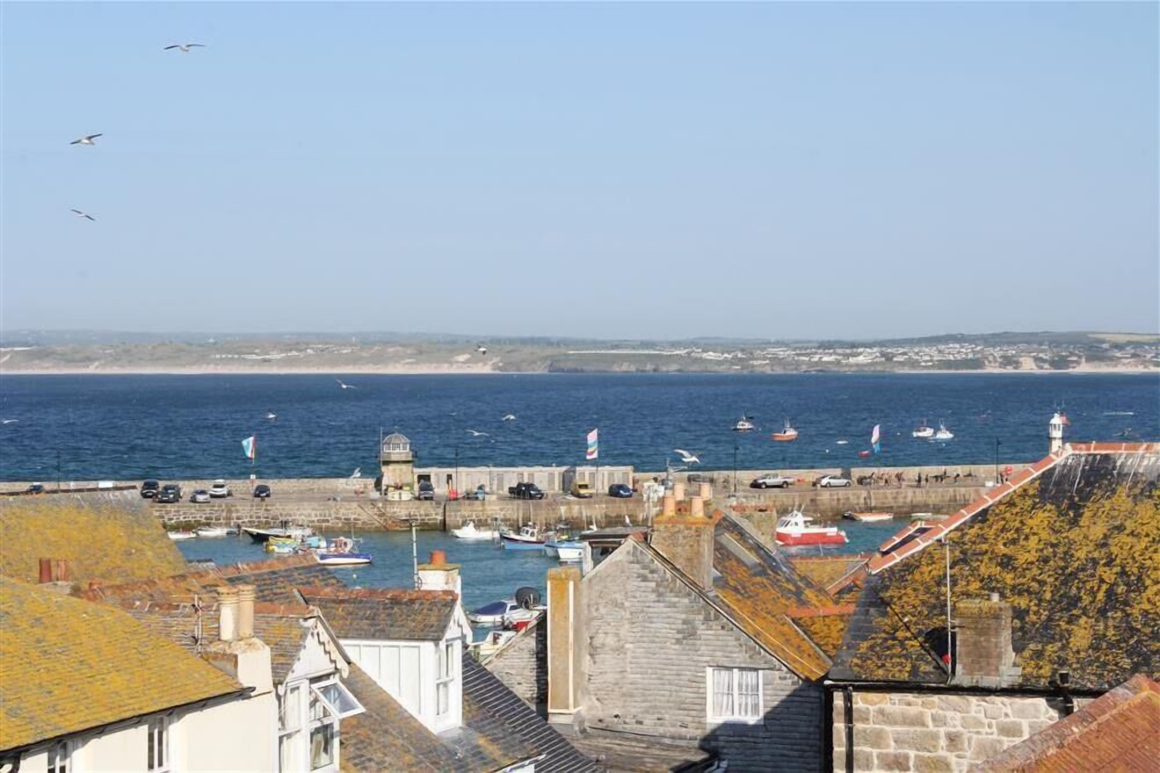 A coastal town with a harbor, boats, and a lighthouse.