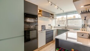 Een moderne keuken met een inbouwoven, een aanrecht en een raam met uitzicht op de stad.