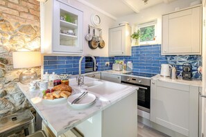 A modern kitchen with a marble countertop, a built-in sink, and a stone wall. - 2 Bed in St Ives (oc-albt02) (St Ives)