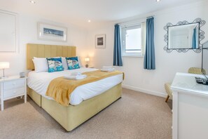 A hotel room with a large bed, a bedside table with a lamp, a chair, and a desk with a mirror. - 2 Bed in St Ives (oc-trev2) (Saint Ives)