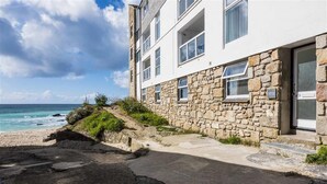 Ein Steinhaus mit einem Balkon mit Blick auf einen Strand.
