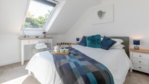 Ein Schlafzimmer mit Bett, Schreibtisch, Stuhl, Fenster und einem Wandbild.