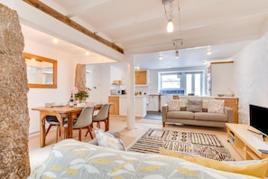 A spacious living area with a dining table, sofa, and a TV. - 1 Bed in St Ives (oc-pmap10) (Saint Ives)
