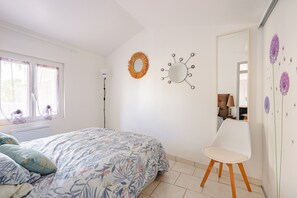 A bedroom with a bed, a chair, a mirror, and wall decorations. - Gîte Le Romarin: Shared Pool, Communal Terrace & Wi-Fi in Courçon (Courçon)