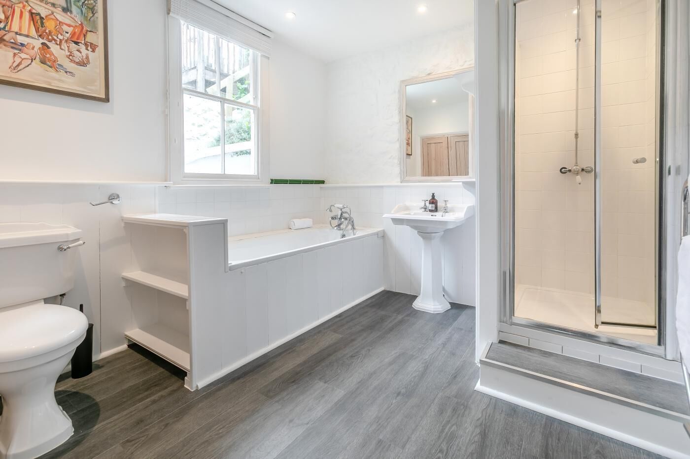 A modern bathroom with a toilet, a bathtub, a sink, and a shower.